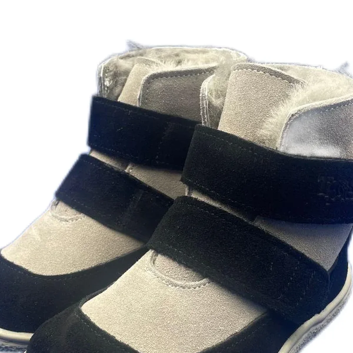 gros plan du haut des bottines enfant noires et grises fourrees a scratch