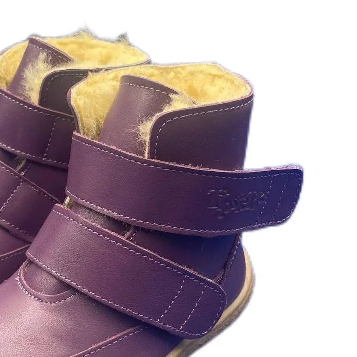 gros plan du haut des bottines enfant violettes fourrees a double scratch