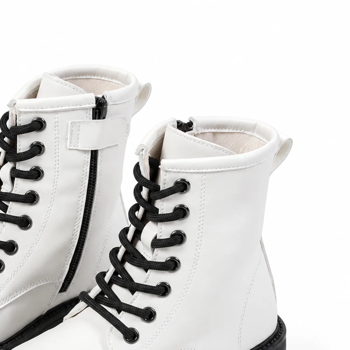 gros plan du haut des bottines fille blanches a lacets et semelle crantee