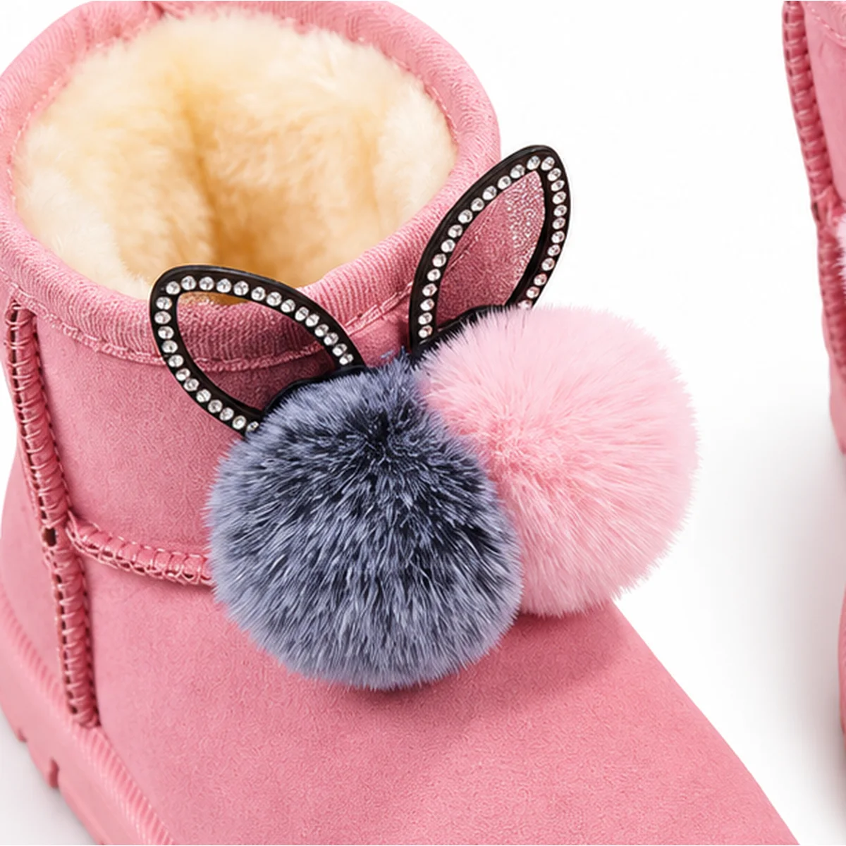 gros plan du haut des bottines fille roses fourrees lapin a pompons