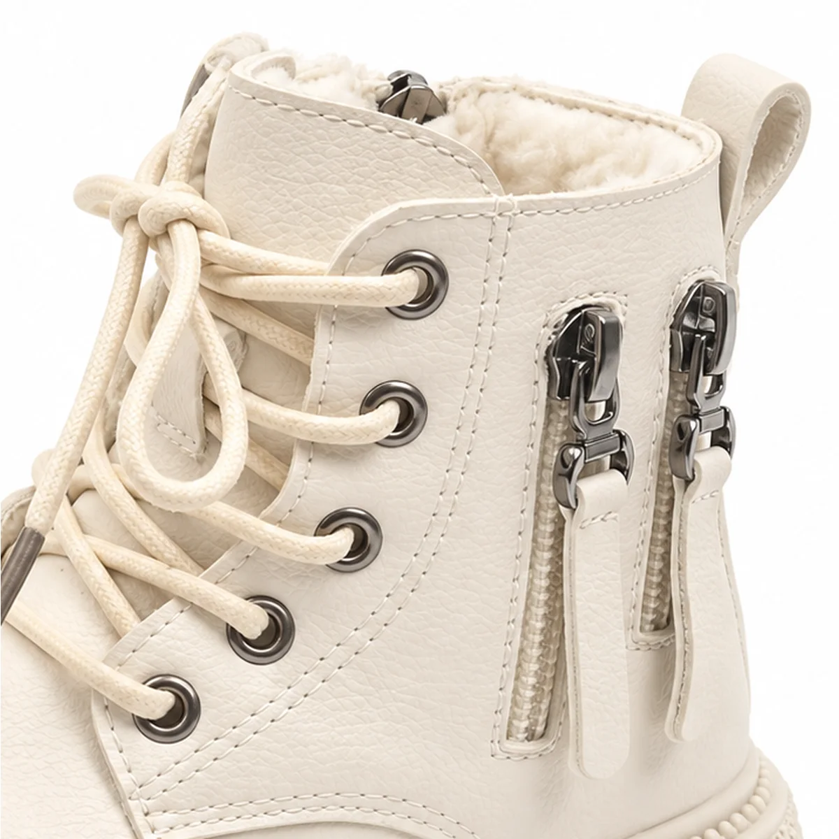 gros plan du haut des bottines garcon beiges fourrees a lacets et zips
