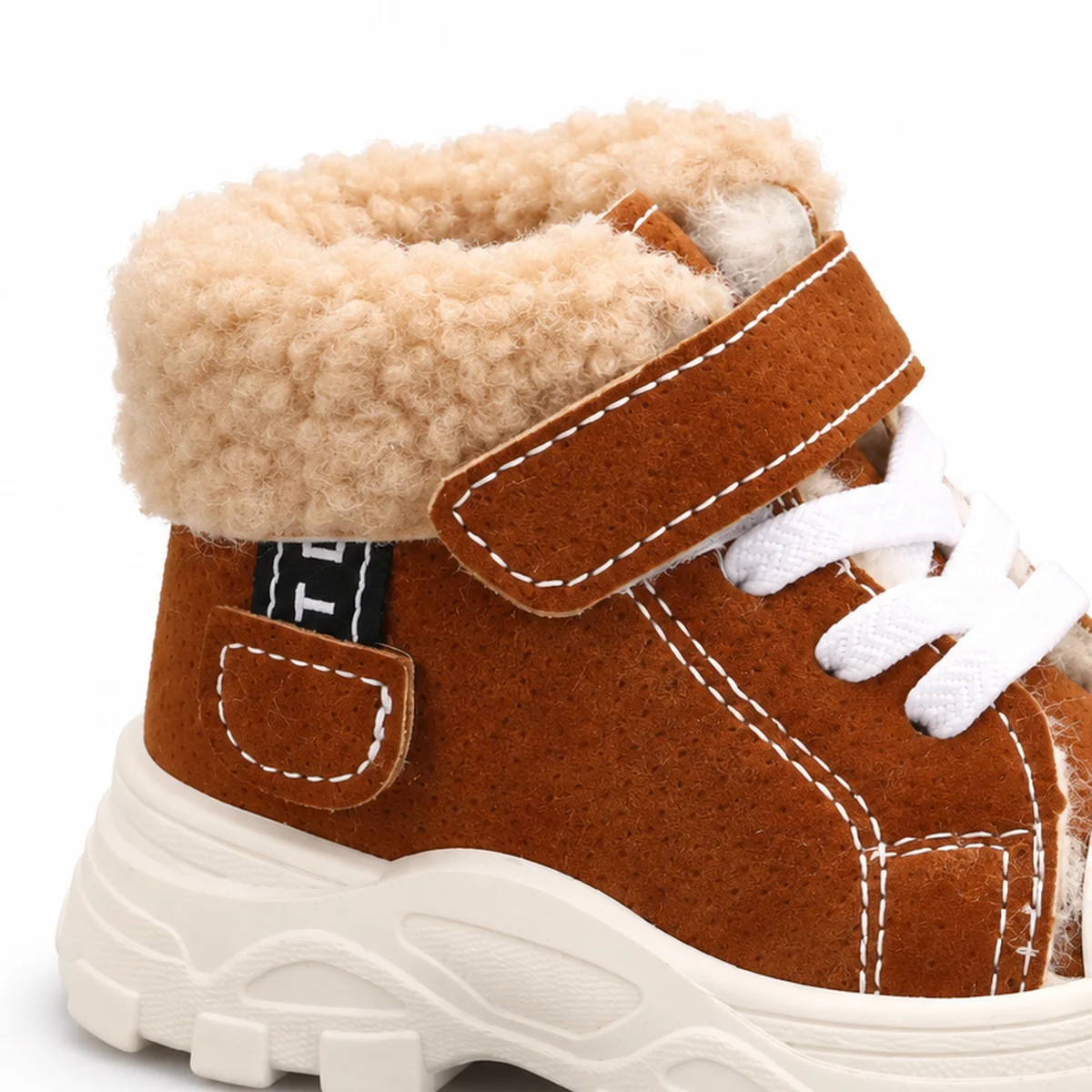 gros plan du haut des bottines garcon marron fourrees a lacets et scratch