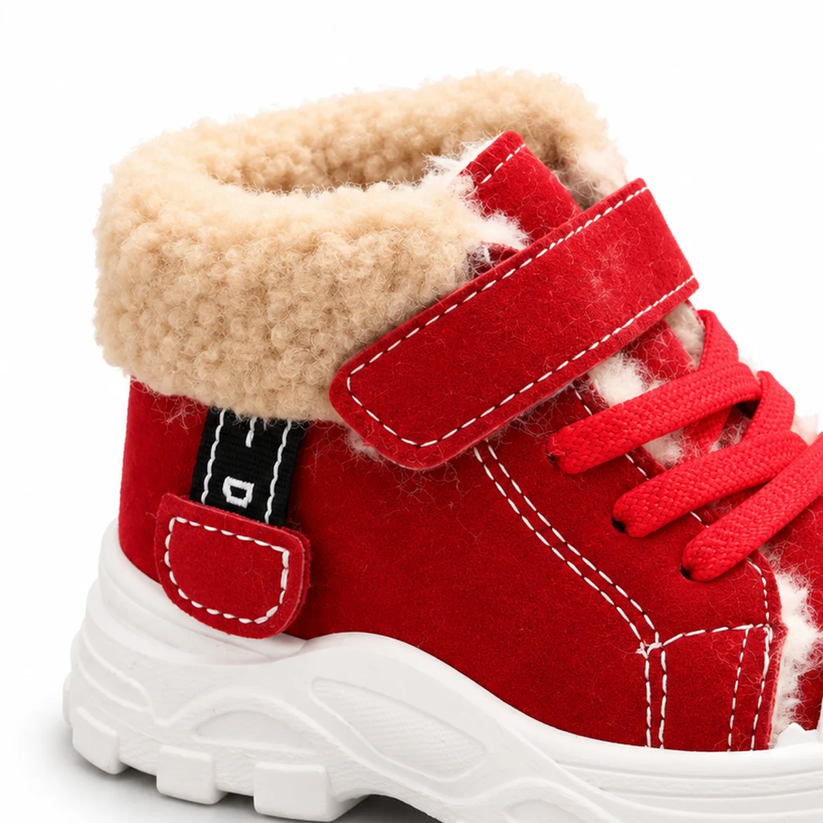 gros plan du haut des bottines garcon rouges fourrees a lacets et scratch
