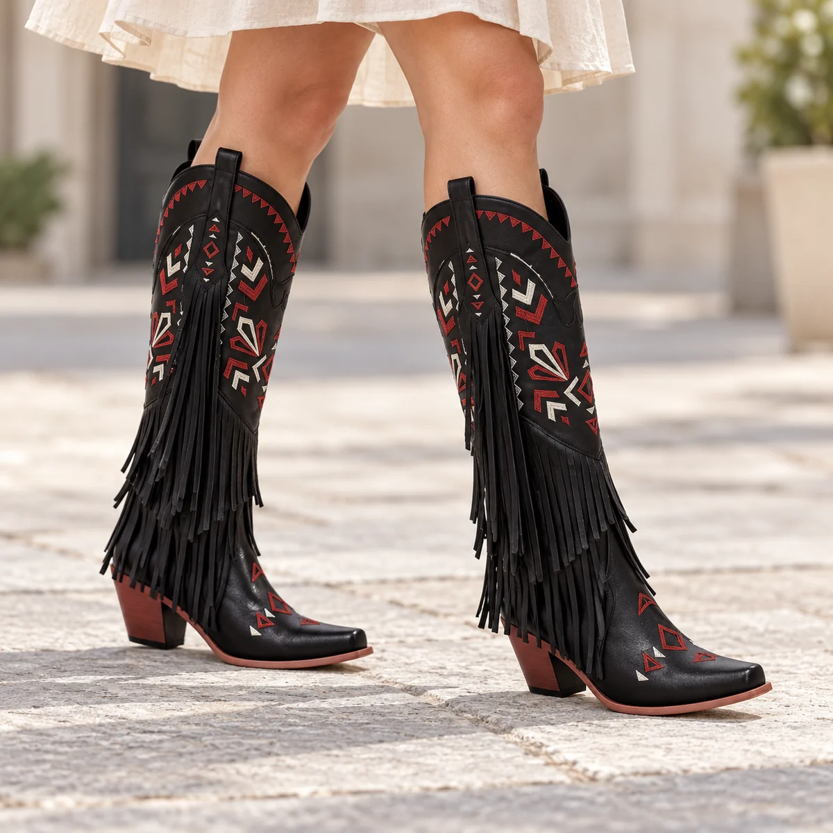 Close-up des bottes femme cowgirl noires avec franges et motifs colorés pour femme mode
