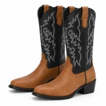 Paire de bottes cowboy bicolores à tige noire brodée sur fond clair.