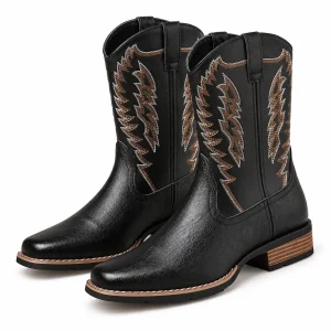 Paire de bottes cowboy noires à broderies en ailes sur fond clair.