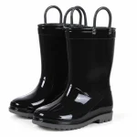 Paire de bottes de pluie noires brillantes à deux anses sur fond clair.