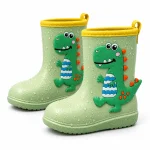 Bottes de pluie vertes à dinosaure en relief présentées sur fond blanc.
