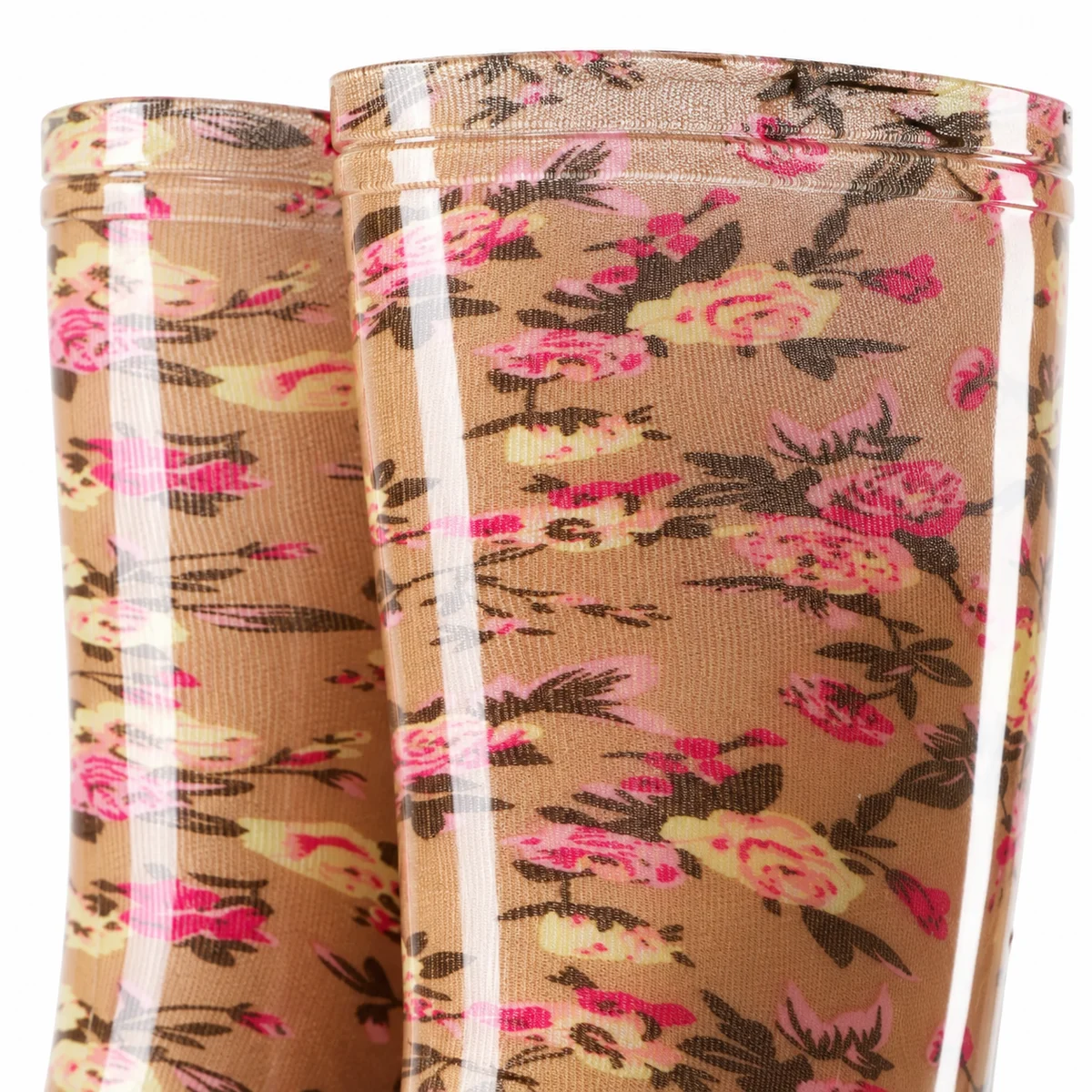Gros plan sur les fleurs roses sur le fond beige de bottes de pluie.