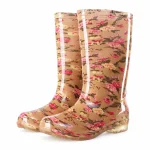 Bottes de pluie beiges à fleurs roses présentées sur fond blanc.