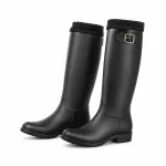 Bottes de pluie noires à boucle et chaussettes présentées sur fond blanc.