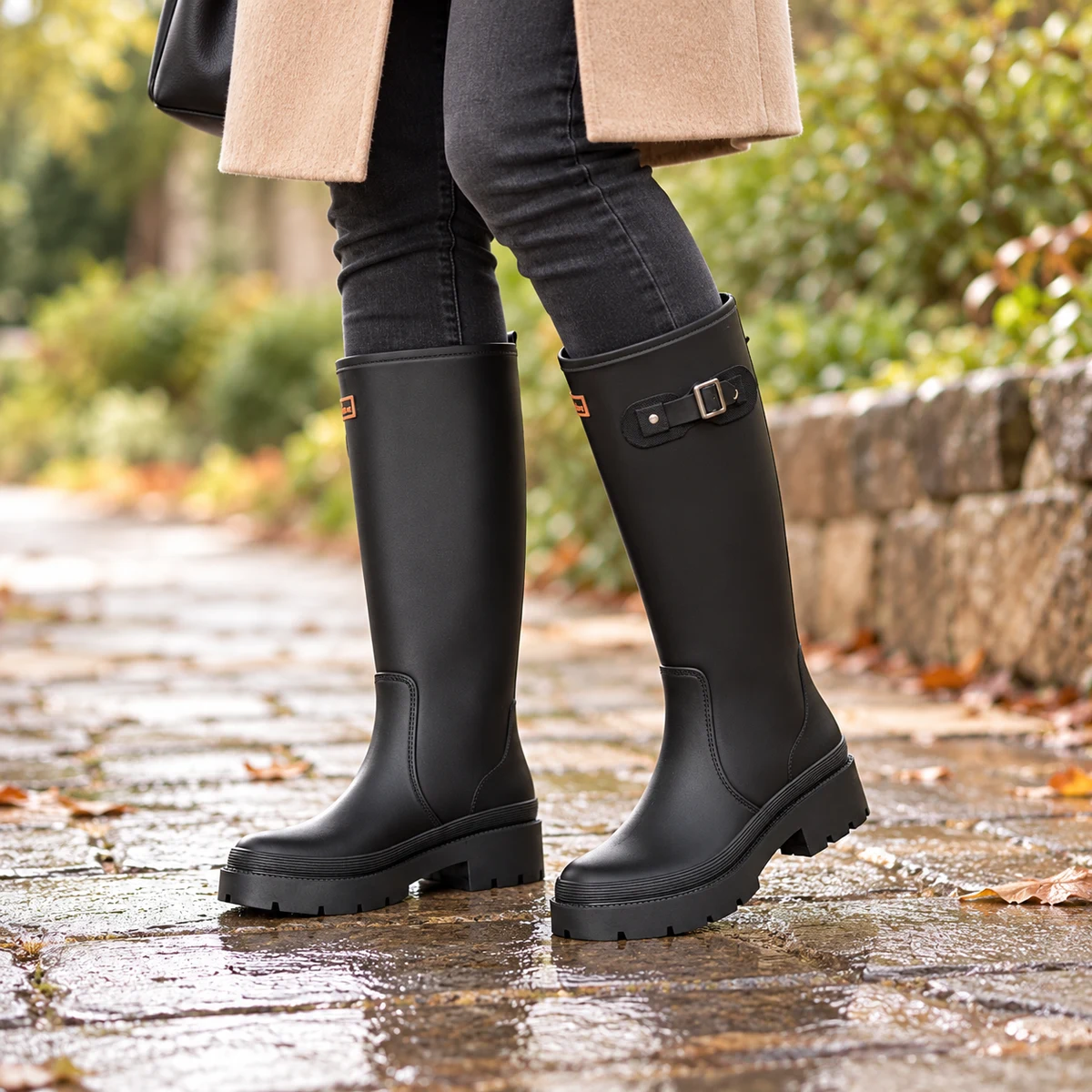 Femme portant des bottes de pluie noires à boucle latérale.