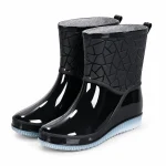 Bottes de pluie noires à col texturé géométrique présentées sur fond blanc.