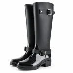 Bottes de pluie noires à deux boucles et talon bas présentées sur fond blanc.