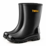 Paire de bottes de pluie noires à col simple sur fond clair.