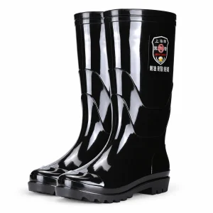 Paire de bottes de pluie noires brillantes à tige haute sur fond clair.