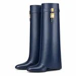 Bottes bleu marine à grand revers et boucle présentées sur fond blanc.