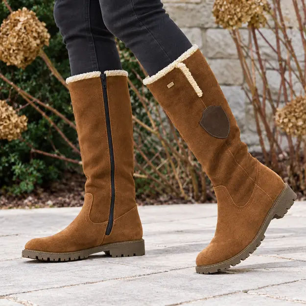 Bottes femme marron à finition veloutée et zip, portées en marchant avec un pantalon sombre