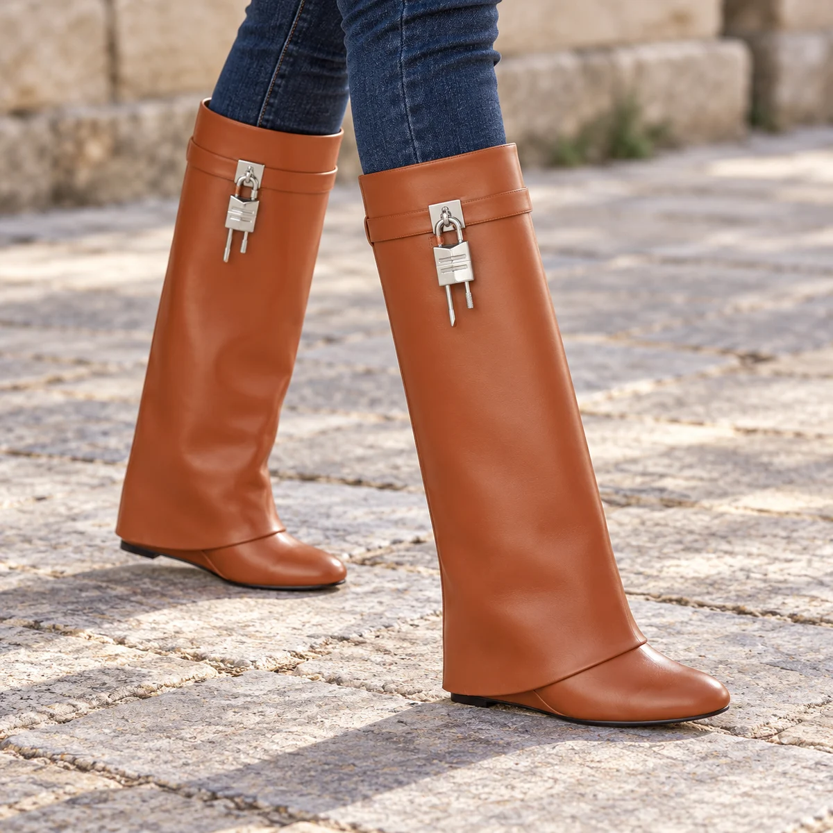 Femme portant des bottes marron clair à grand revers et boucle sur un chemin.