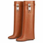 Bottes marron clair à grand revers et boucle présentées sur fond blanc.