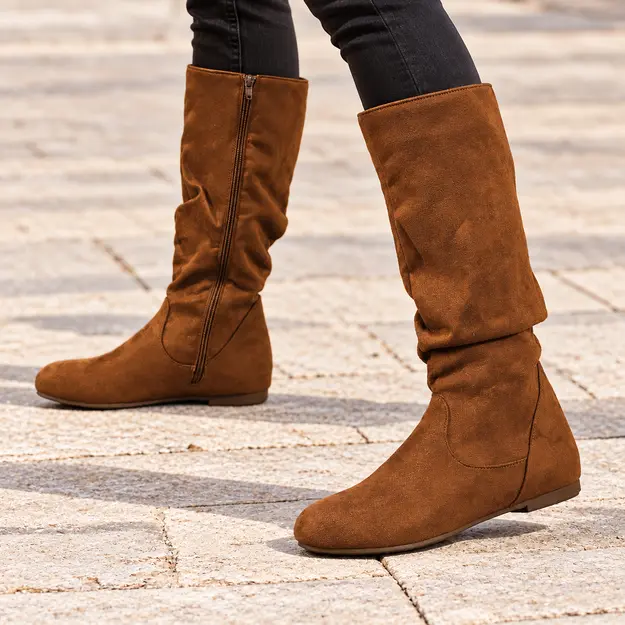 bottes femme marron plissees a talon bas portees en marchant avec un pantalon sombre 44783