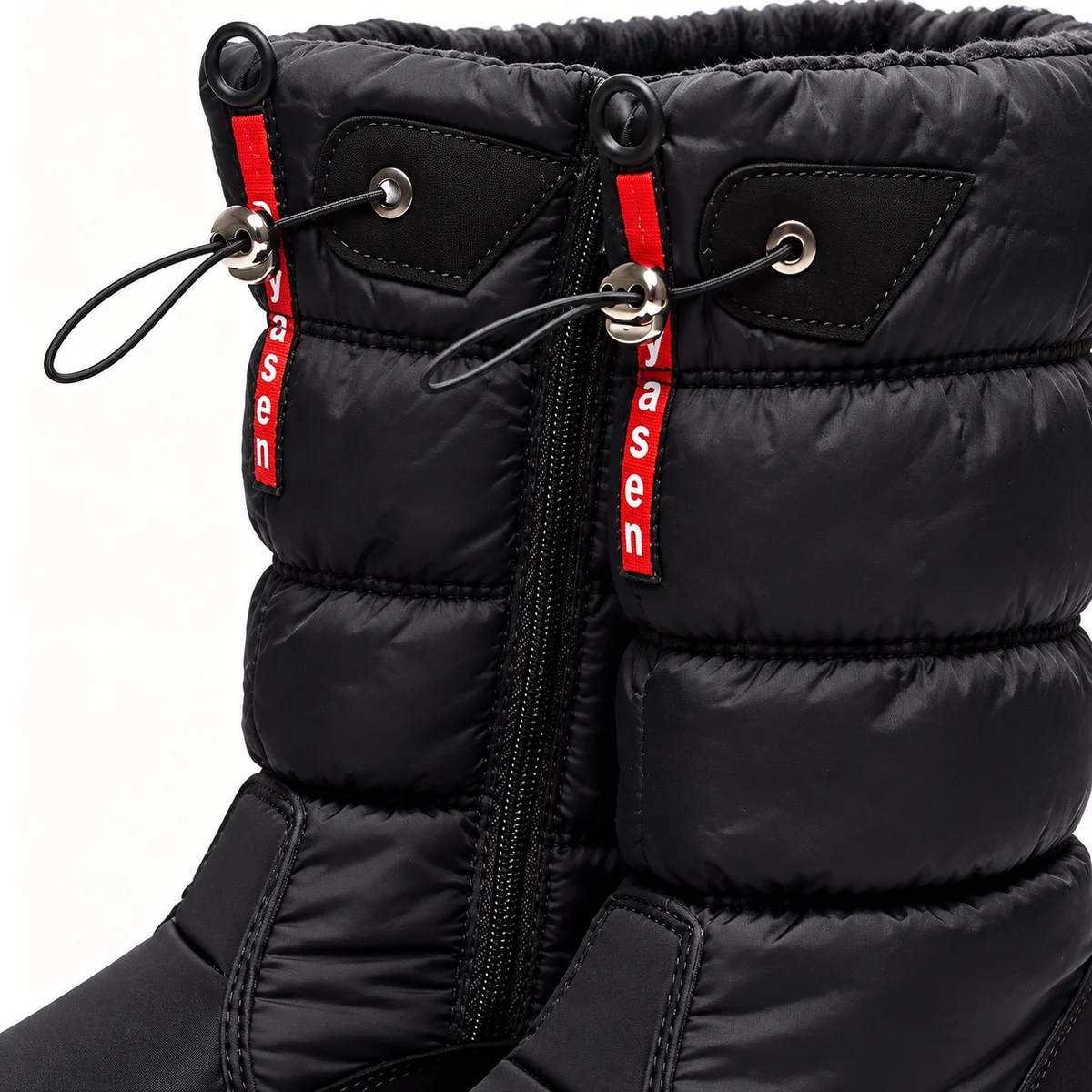 Femme portant des bottes noires matelassées à zip et cordon, vue de profil