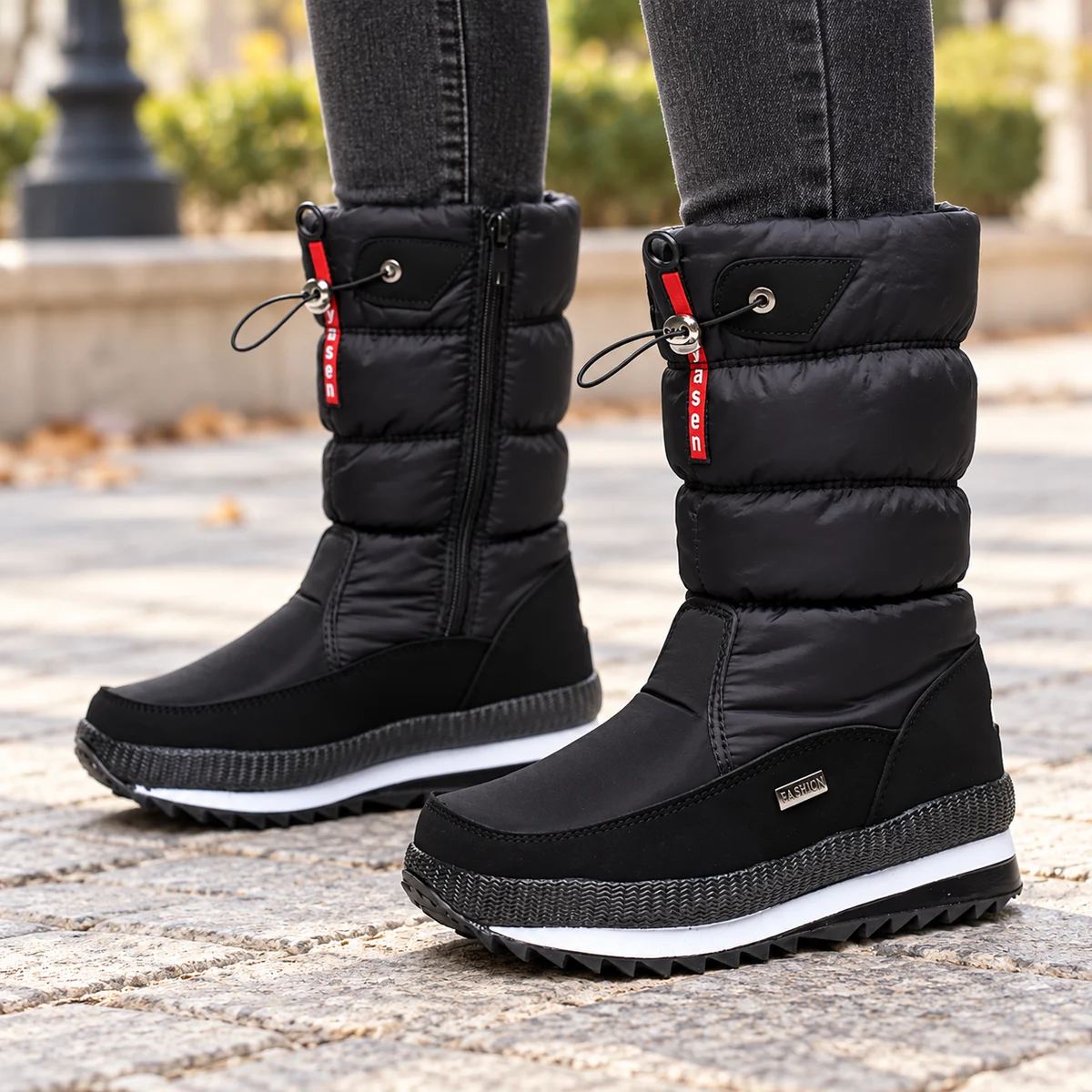 Close-up des bottes noires matelassées avec fermeture éclair et cordon de serrage