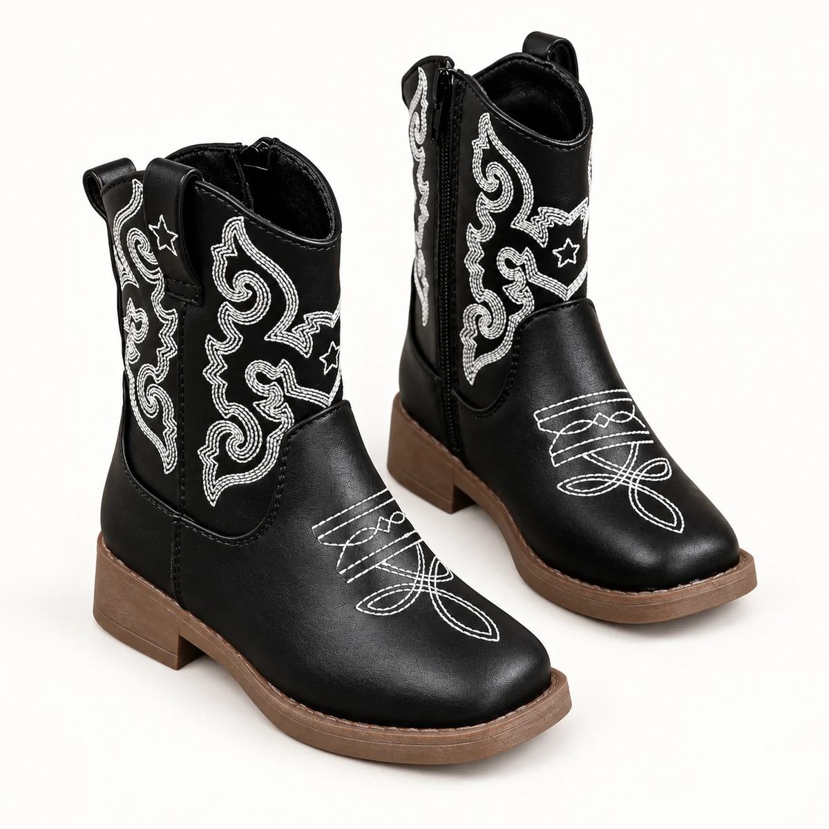 Jeune fille portant bottines cowboy noires à broderies blanches