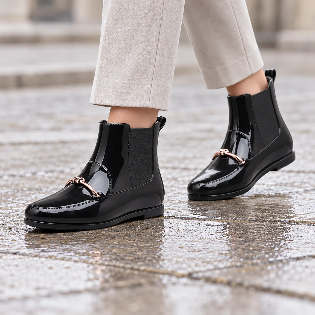 Détail des bottines de pluie noires à ornement métallique pour femme