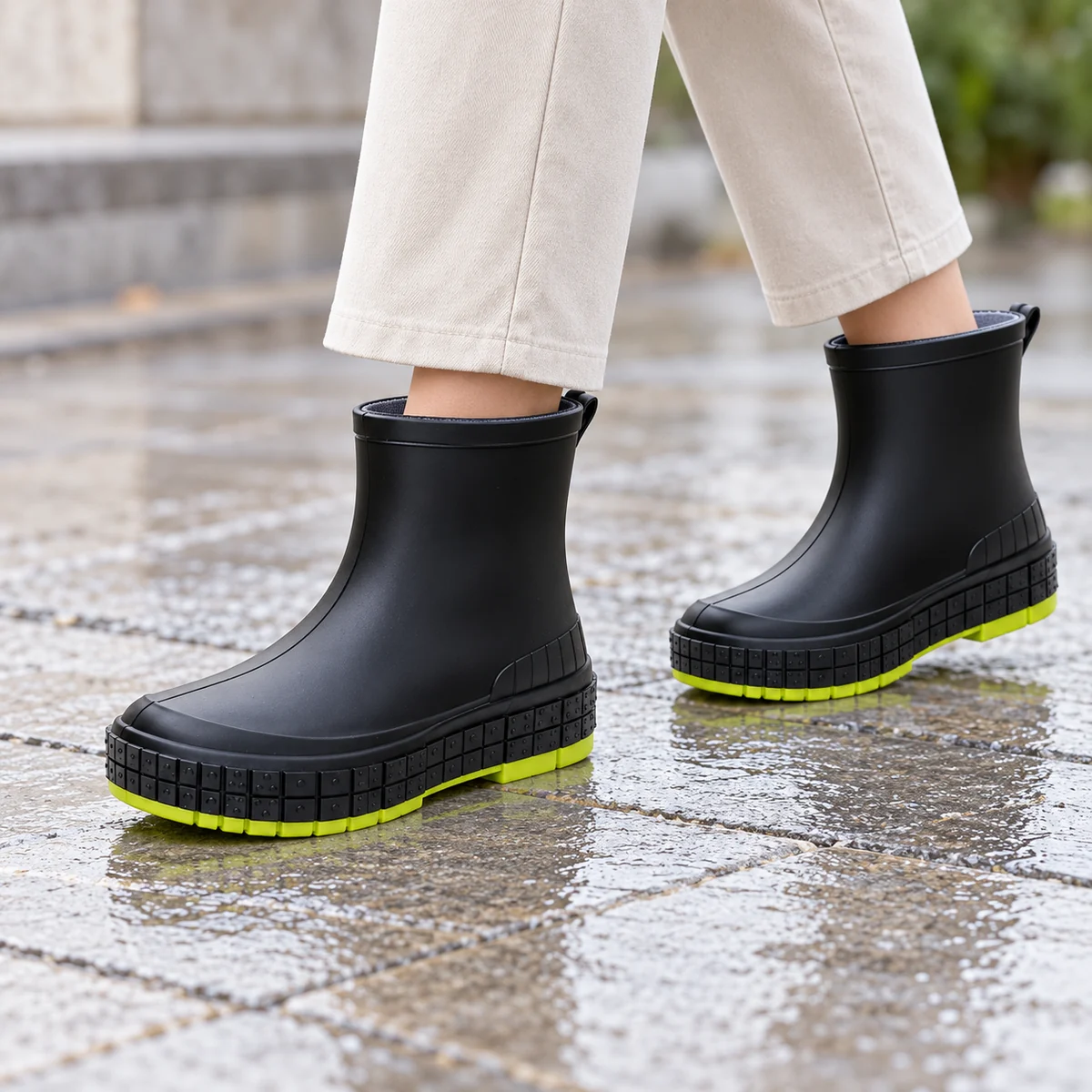 Femme portant des bottines de pluie noires à semelle vert vif style décontracté