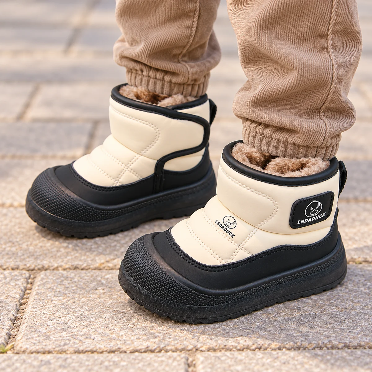 Little kid wearing bicolored fur-lined boots with wide velcro strap