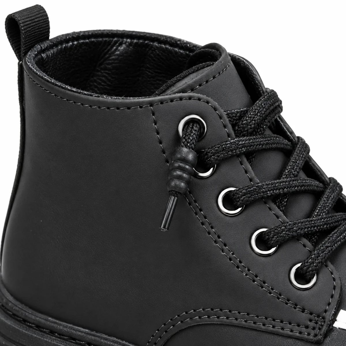 Enfant marchant en bottines noires à lacets et détails de style