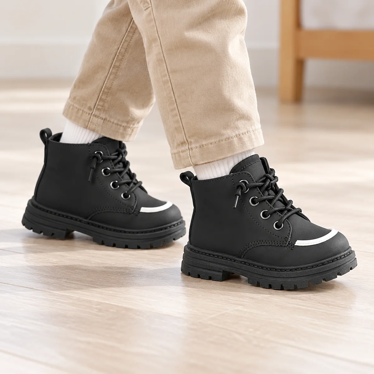 Jeune fille portant des bottines noires à lacets et bout coloré
