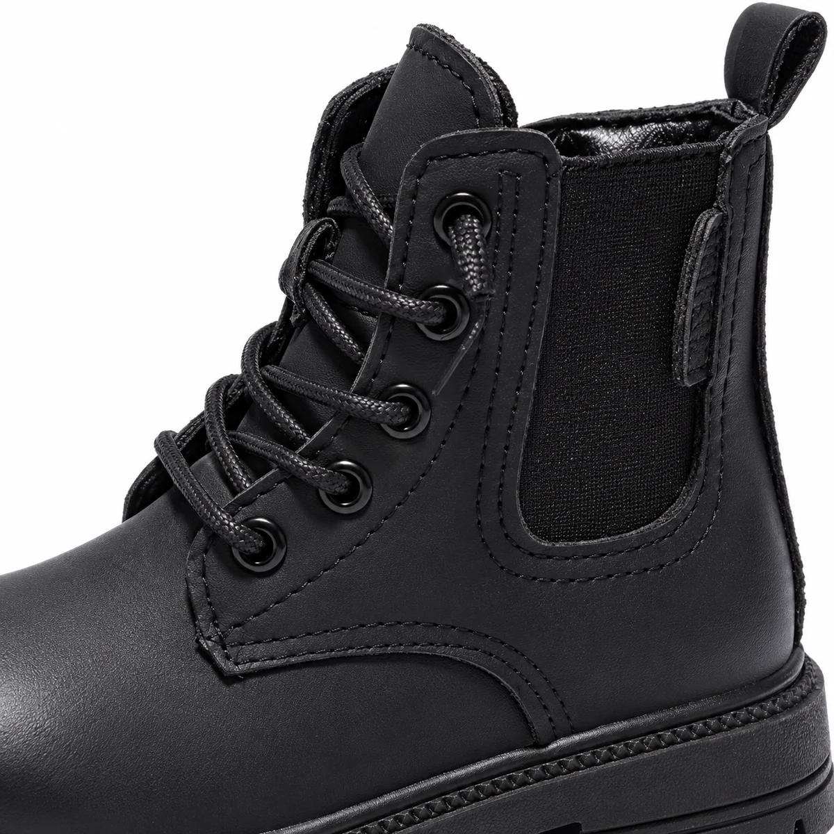Bottines enfant modernes noires avec empiècement tendance à côté de chaussures