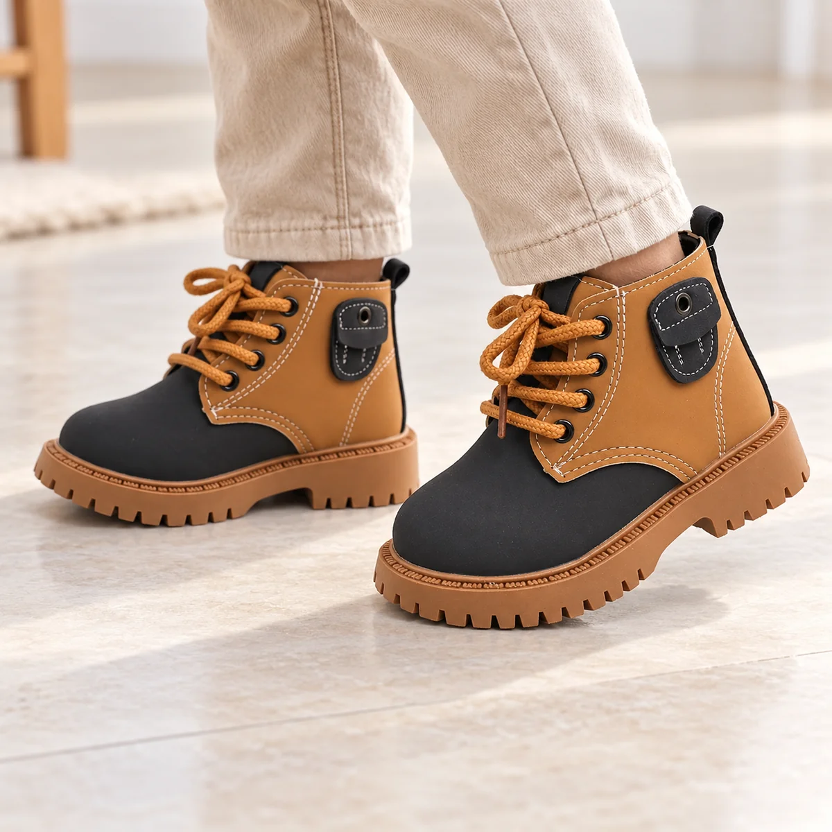 Enfant portant des bottines noires et camel à lacets confortables
