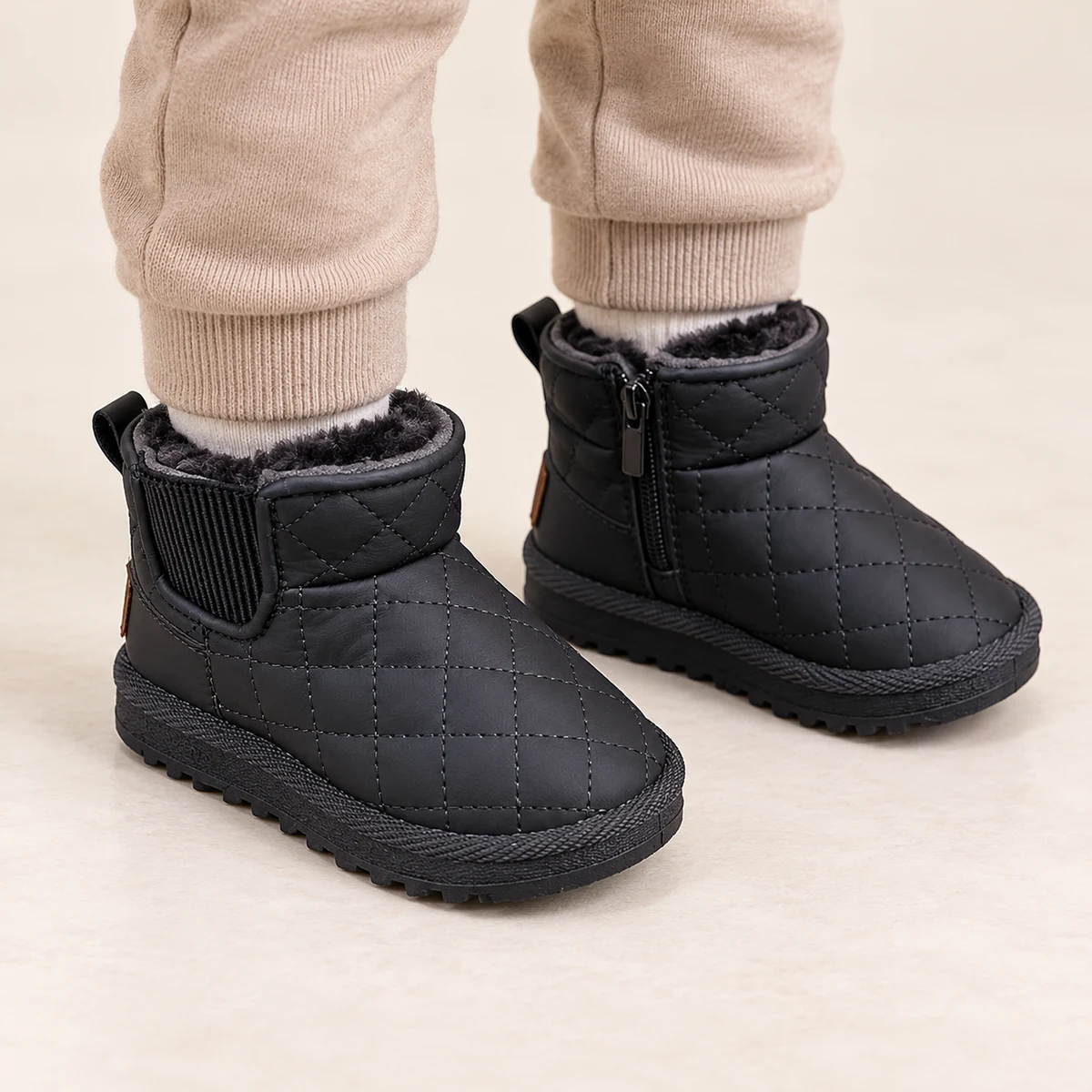 Enfant portant bottines noires fourrées à fermeture éclair