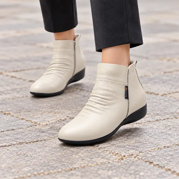 bottines femme beiges fourrees et compensees portees en marchant avec un pantalon sombre 45071