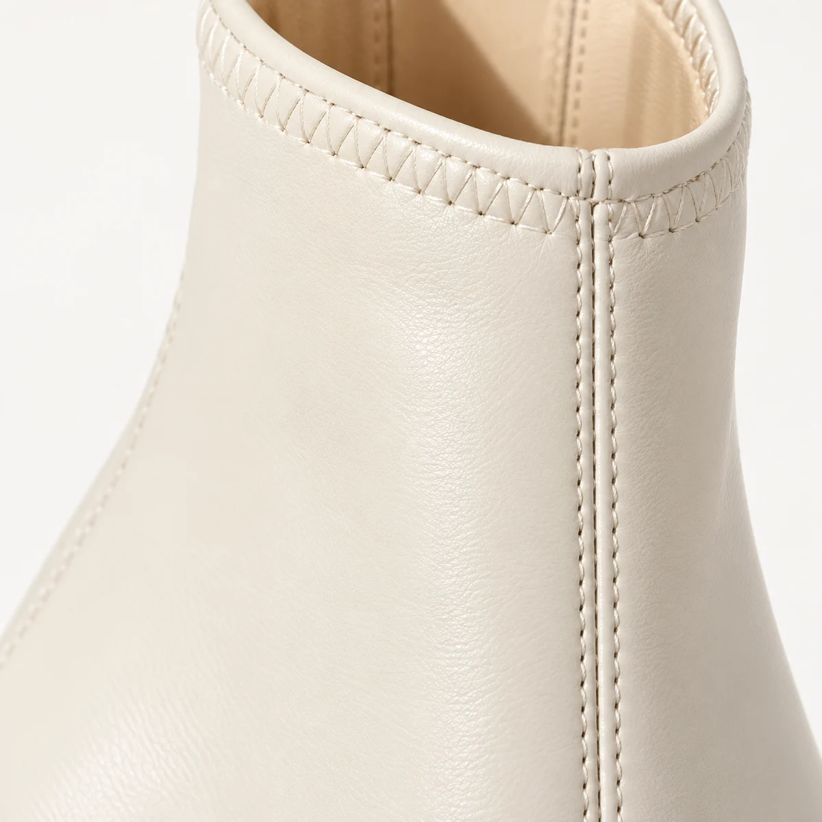 Détail des bottines femme blanches avec talon évasé et design moderne