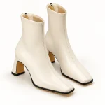 Bottines femmes blanches à bout carré et talon évasé sur fond neutre