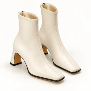 Bottines femmes blanches à bout carré et talon évasé sur fond neutre