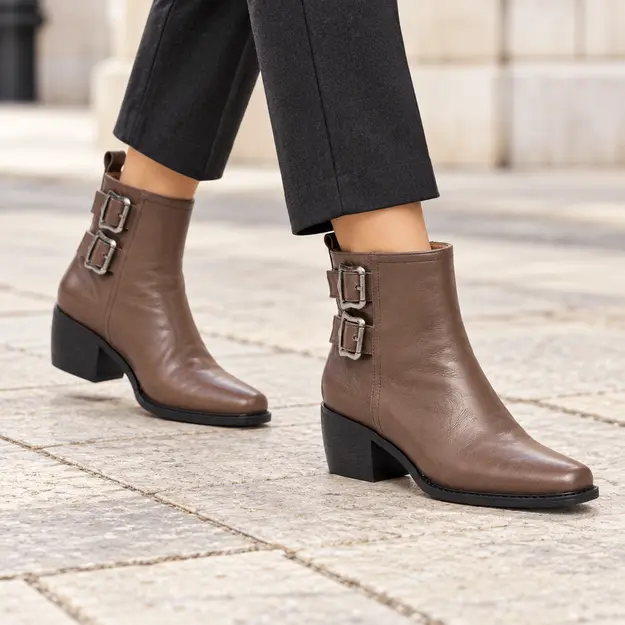 bottines femme en cuir fourrees a boucle 5 cm marron fourre portees en marchant avec un pantalon sombre 45088
