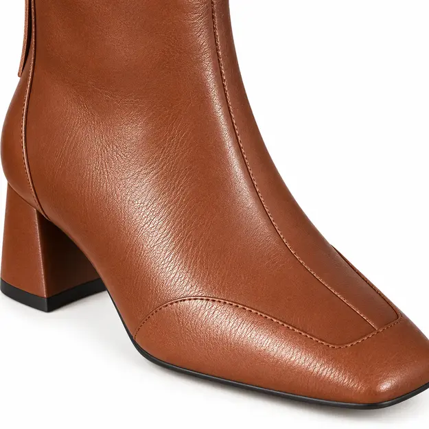 Femme portant des bottines en cuir marron fourrées à talon pour hiver
