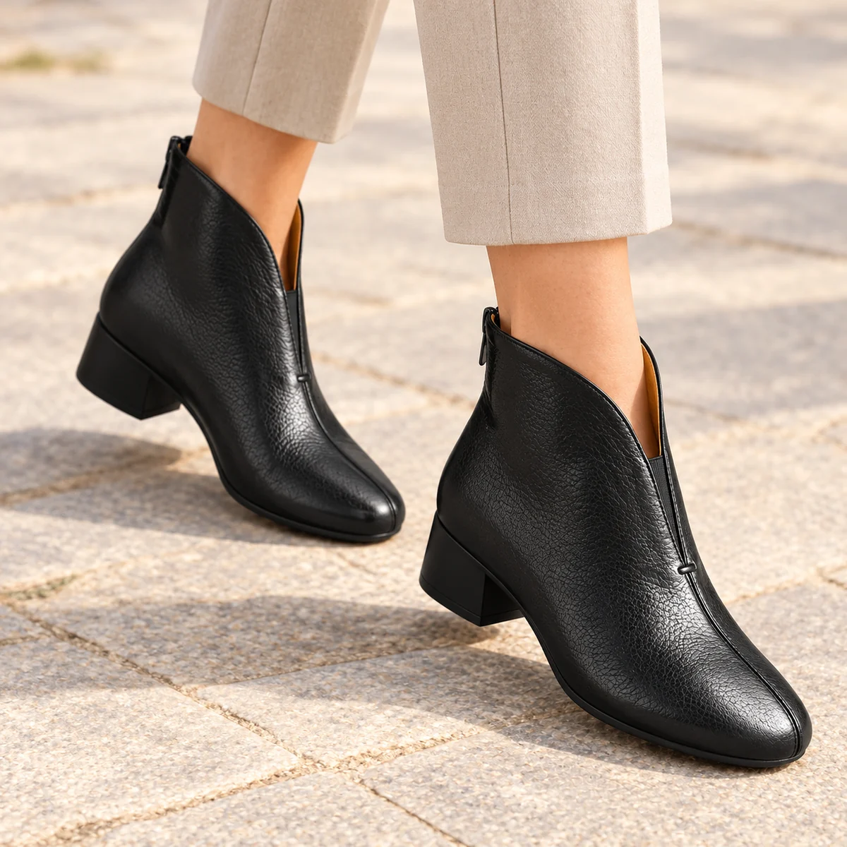 Close-up des bottines femme en cuir noir avec zip arrière et semelle résistante