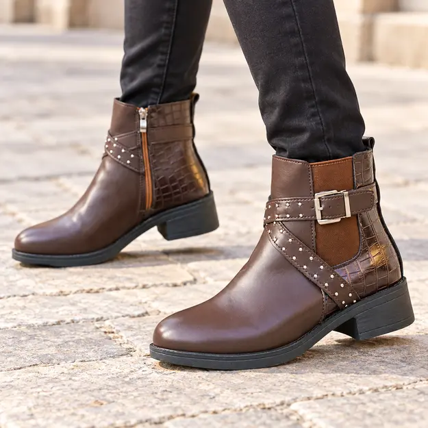 bottines femme marron a boucles et clous portees en marchant avec un pantalon sombre 45050