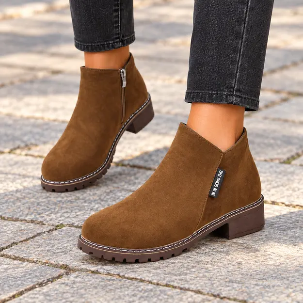 bottines femme marron a zip et finition mate portees en marchant avec un pantalon sombre 44742