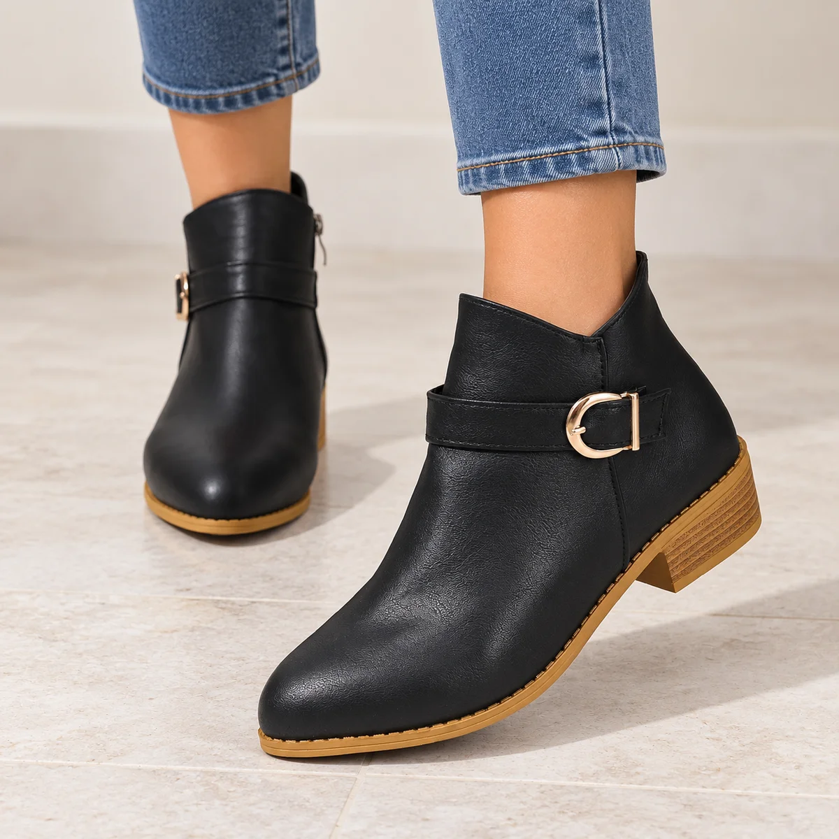 Détails de la boucle dorée sur les bottines noires à bride fine pour femme