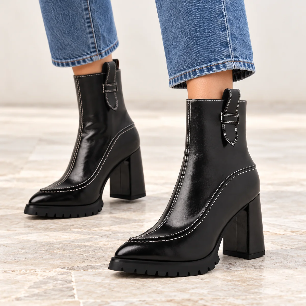 Vue de côté des bottines noires à talon élégant et semelle crantée pour femme