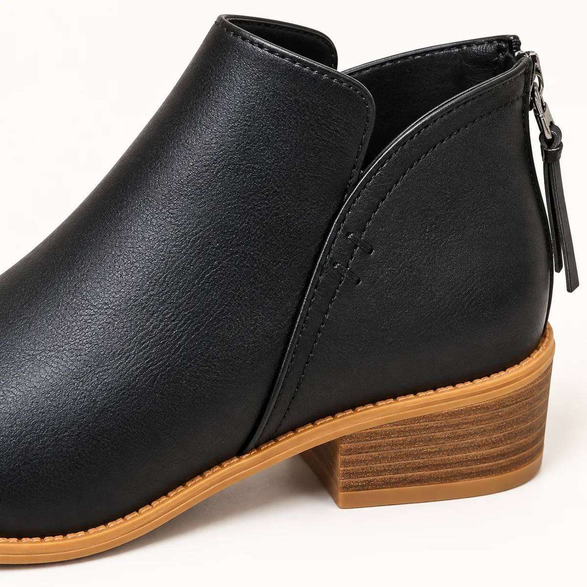Femme porteuse de bottines noires à zip arrière et col échancré tendance