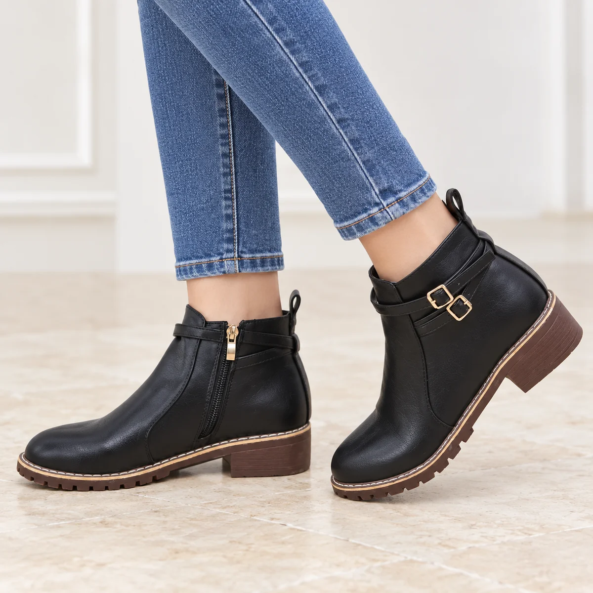 Détail de la fermeture à zip et boucle sur les bottines noires féminines