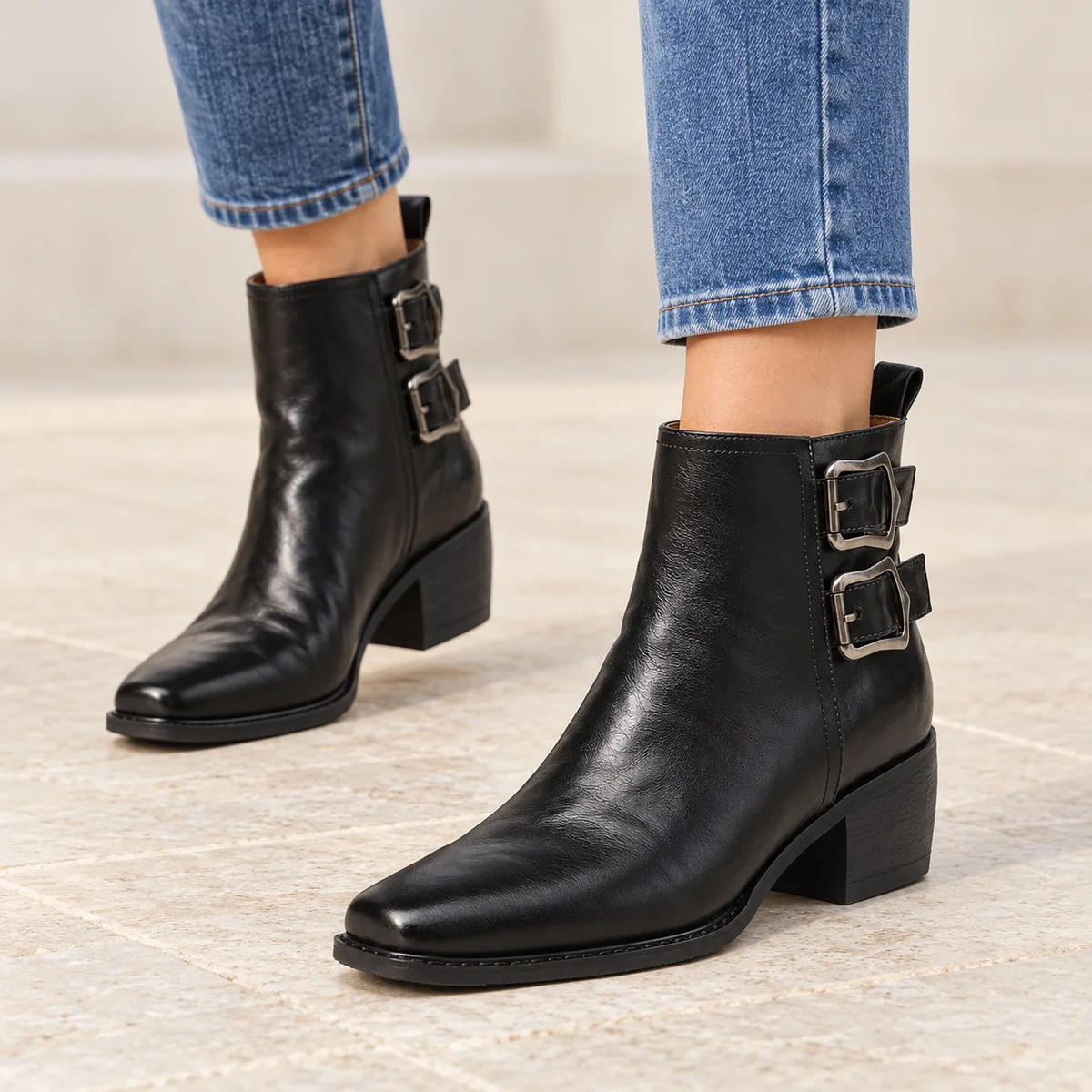 Détail des bottines noires fourrées à double boucle pour femme